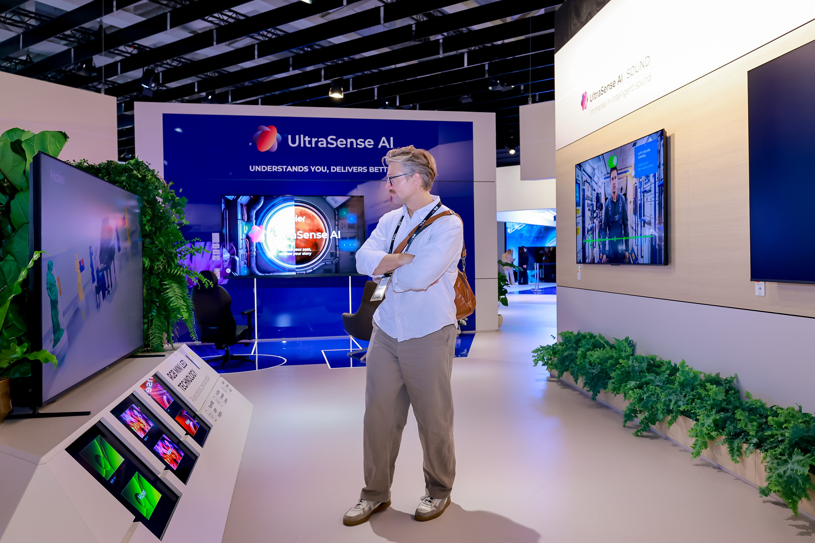 Visitor viewing Haier UltraSense AI television displays at the IFA stand