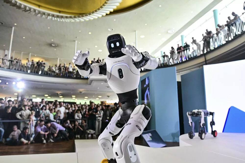 Humanoid robot moving on the IFA stage in front of a standing audience