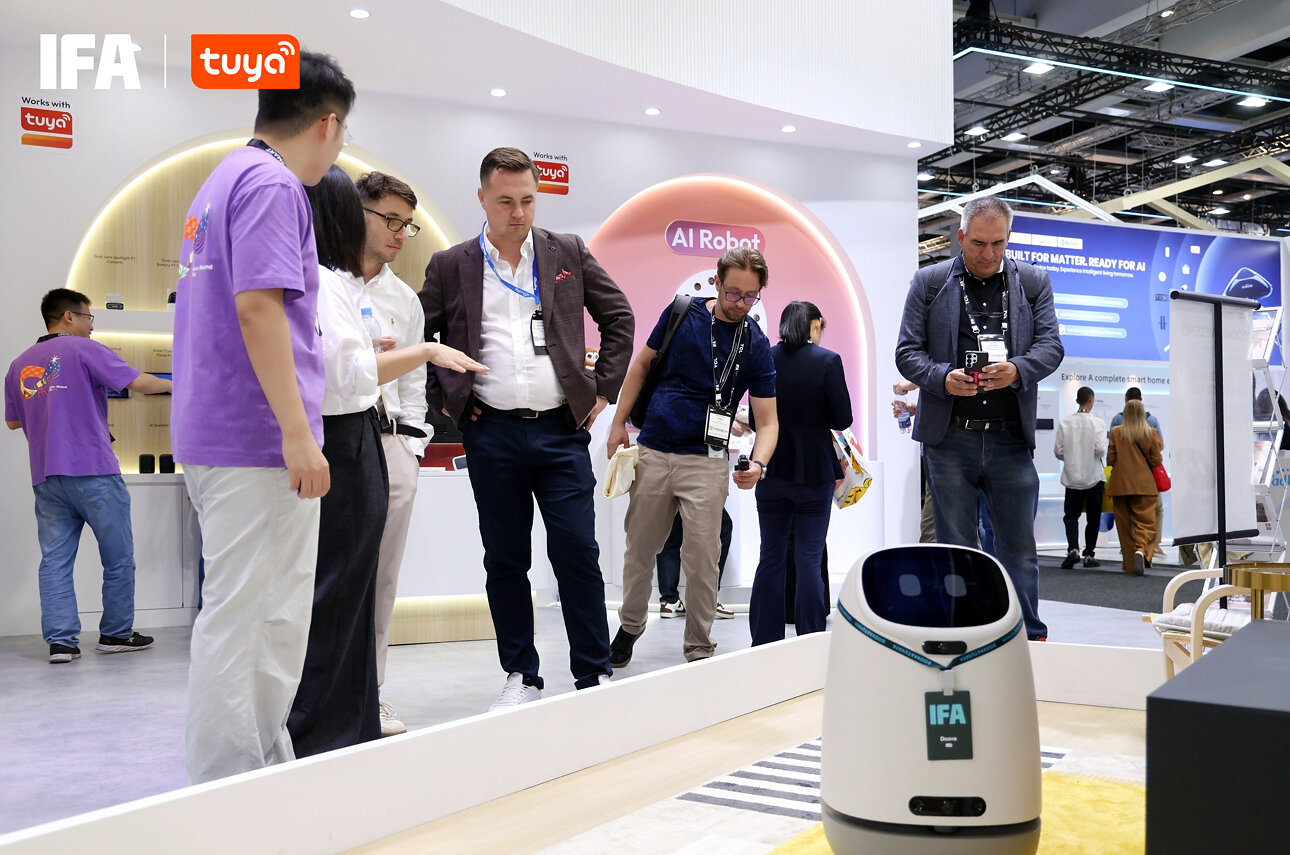Visitors at Tuya's IFA stand beside a robot and a Matter product display