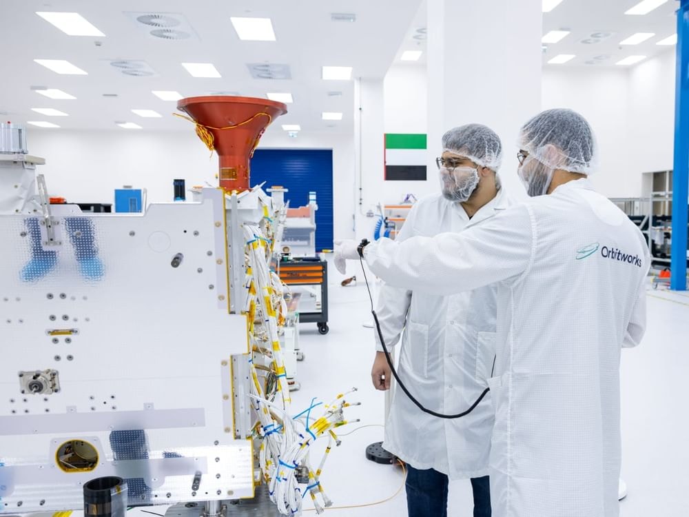 Technicians inspect satellite hardware in the Orbitworks production facility