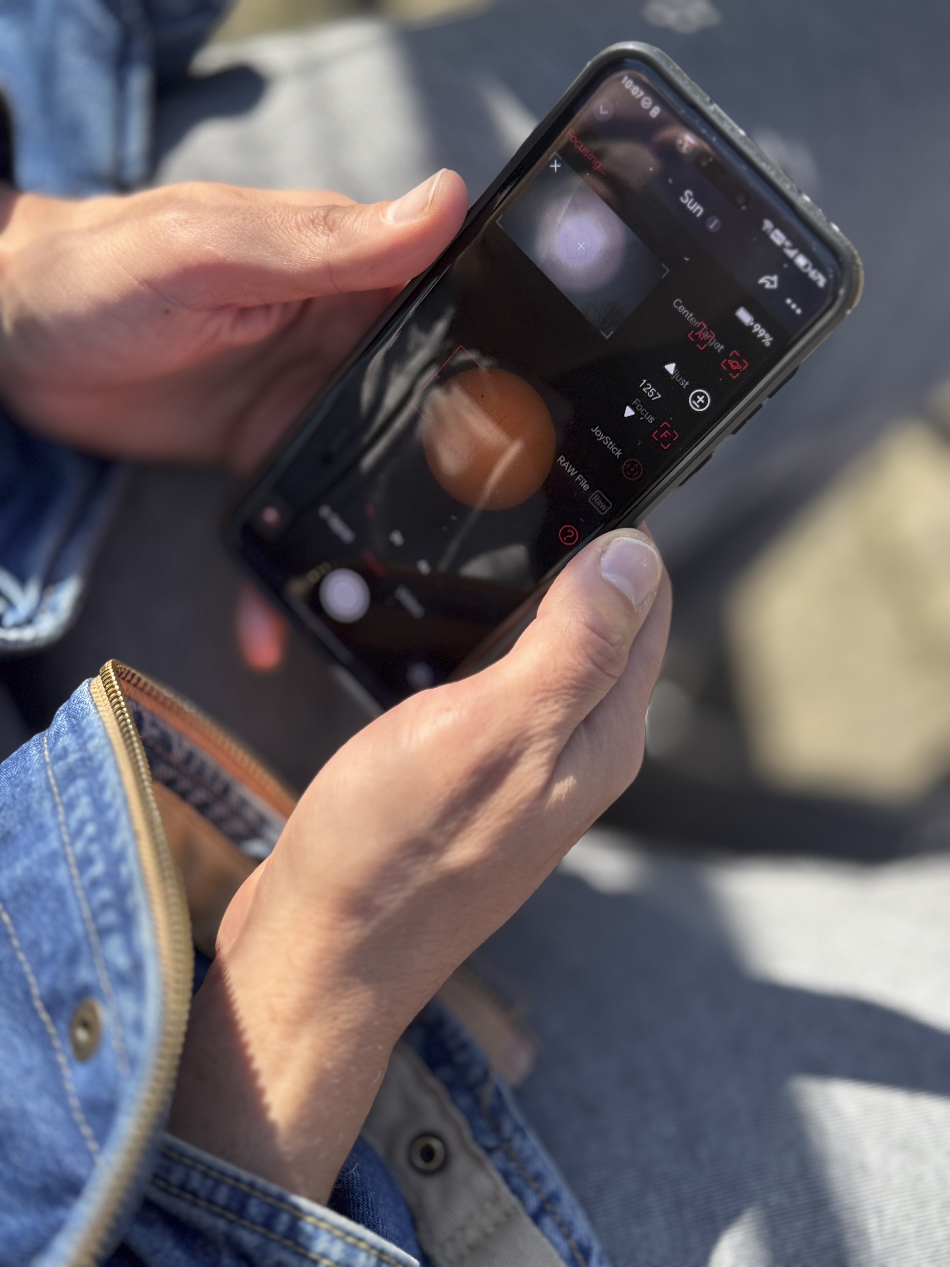 Person holding a smartphone with the camera app open outdoors